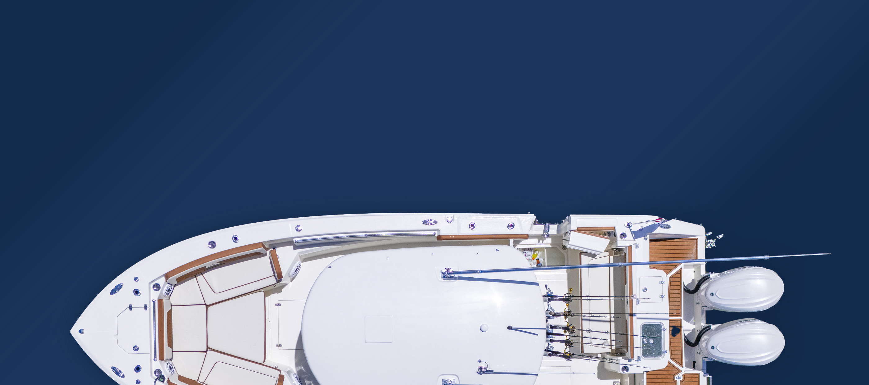 Overhead view of a sleek white boat on deep blue water. The boat's deck features fishing rods and twin outboard motors, conveying a sense of adventure.